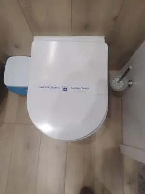 a white toilet with a sign on it in a bathroom at Mumin in Carini