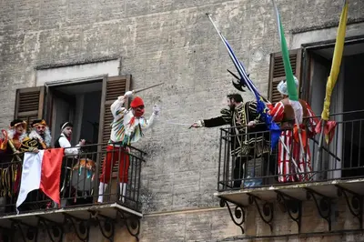 a group of people standing on a balcony with flags at Tra chiazza e casteddu in Mezzojuso