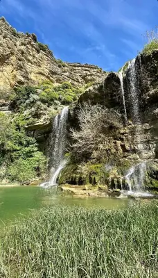 a waterfall on the side of a mountain next to a pond at Tra chiazza e casteddu in Mezzojuso
