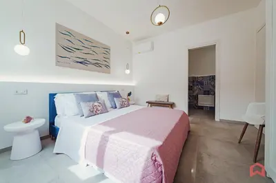 a white bedroom with a bed with a pink blanket at Deliziosa Villa con Piscina e Jacuzzi a Scopello in Castellammare del Golfo