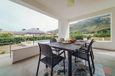a dining room with a table and chairs and a pool at Deliziosa Villa con Piscina e Jacuzzi a Scopello in Castellammare del Golfo