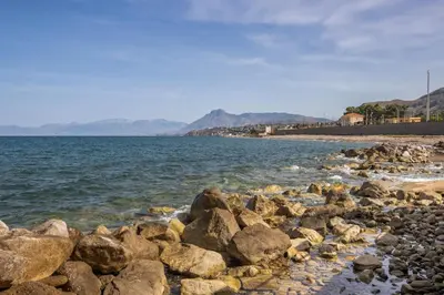 a group of rocks on a beach near the water at Richgood Luxury homes - Villa Zefira mare in Altavilla Milicia