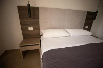 a small bedroom with a bed and a night stand at Richgood Luxury homes - Villa Zefira mare in Altavilla Milicia