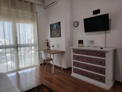 a bedroom with a dresser and a table and a television at FALSTAFF 2 Apartment in Palermo