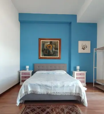 a blue bedroom with a bed and two night stands at FALSTAFF 2 Apartment in Palermo