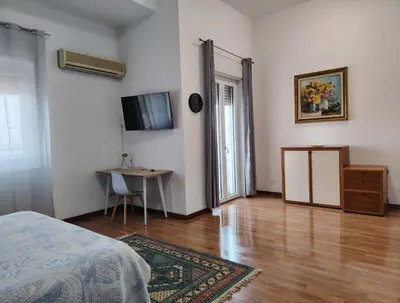 a room with a bed and a table and a television at FALSTAFF 2 Apartment in Palermo