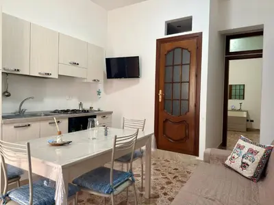 a kitchen with a table and chairs and a kitchen with a door at Casa Costa in Capaci
