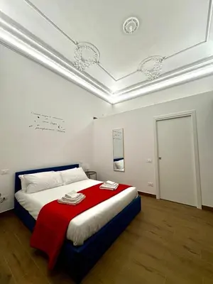 a bedroom with a bed with a red blanket at Gea Apartment in Palermo