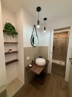 a flat screen tv hanging on a wall with plants at Gea Apartment in Palermo