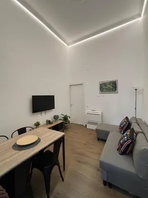 a patio with chairs and a table and plants at Gea Apartment in Palermo