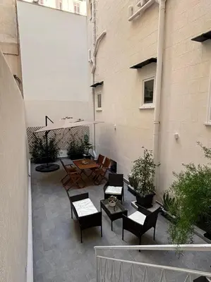a wooden table and chairs under a large umbrella at Gea Apartment in Palermo