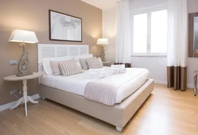 a bedroom with a large white bed and a table at Suite 136 in Palermo