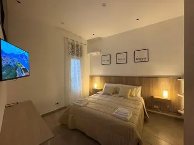 a bedroom with a large bed and a flat screen tv at Le mura di San Vito in Palermo