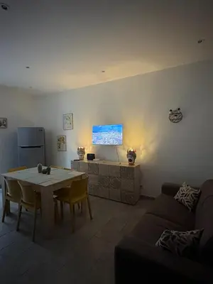 a living room with a table and a tv at Le mura di San Vito in Palermo