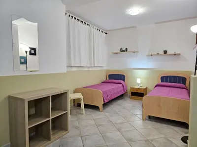 two beds in a room with purple sheets at Holiday Home Villa mit Wasserblick by Interhome in Cefalù