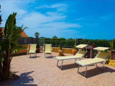 a group of chairs and tables on a patio at Holiday Home Villa mit Wasserblick by Interhome in Cefalù