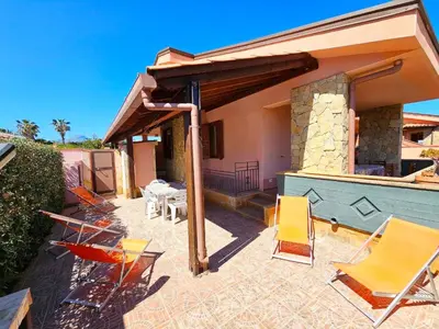 a patio with a bunch of chairs and a building at Holiday Home Helle mediterrane Villa mit Veranda und Garten by Interhome in Cefalù