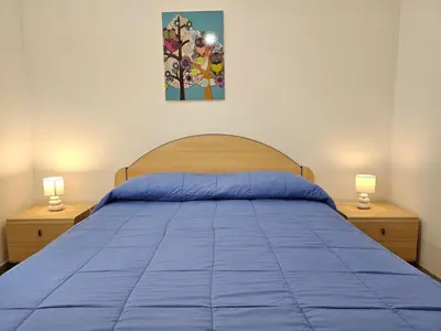 a bedroom with a blue bed with two lamps at Holiday Home Helle mediterrane Villa mit Veranda und Garten by Interhome in Cefalù