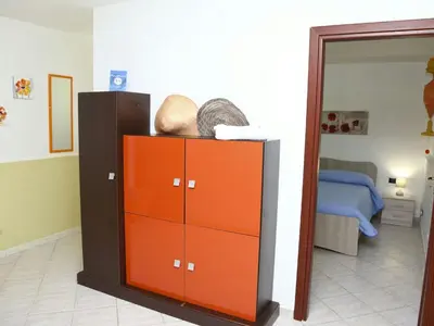 a bedroom with an orange cabinet and a bed at Holiday Home Helle mediterrane Villa mit Veranda und Garten by Interhome in Cefalù