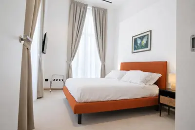 a bedroom with a bed and a large window at Dimora Monteleone in Palermo