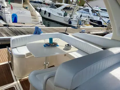 a white boat with a table on a dock with boats at Palermo Boat Experience in Isola delle Femmine