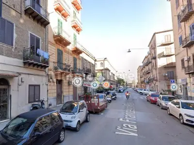 a city street with cars parked on the side of the road at Magic House in Palermo