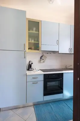 a kitchen with white cabinets and a black oven at Vista Monte Cofano in Castelluzzo