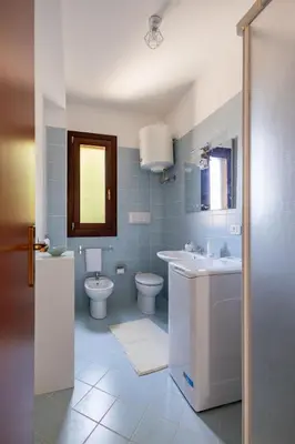 a bathroom with a sink and a toilet and a mirror at Vista Monte Cofano in Castelluzzo