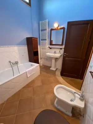 a bathroom with a tub and a toilet and a sink at Baglio Cuttaia in Carini