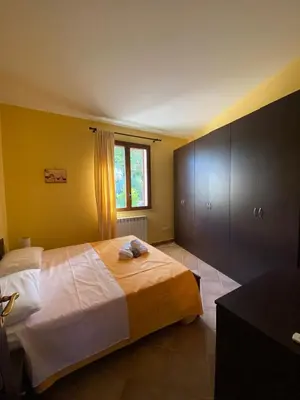a bedroom with a large bed and a window at Baglio Cuttaia in Carini