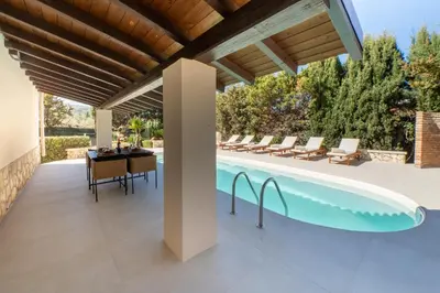 an outdoor patio with a pool and a table and chairs at Exclusive Villa Eden in Castellammare del Golfo