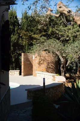 a brick wall and a bench in a yard at Exclusive Villa Eden in Castellammare del Golfo