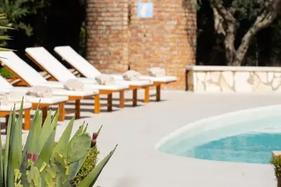a row of lounge chairs next to a swimming pool at Exclusive Villa Eden in Castellammare del Golfo