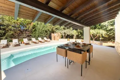 an outdoor patio with a table and chairs next to a swimming pool at Exclusive Villa Eden in Castellammare del Golfo