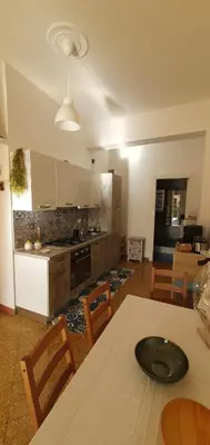 a kitchen and living room with a table and chairs at Magia del Sud in Palermo