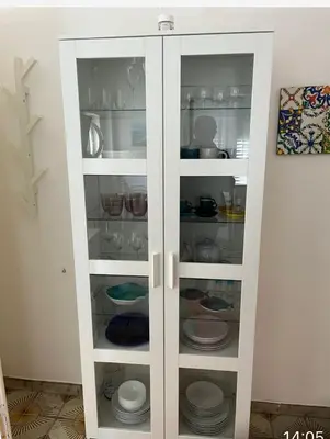 a white cabinet filled with plates and dishes at Chiaro di luna holiday in Palermo