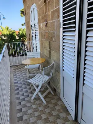 a table and chairs on the balcony of a house at Chiaro di luna holiday in Palermo