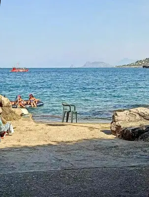 a group of people swimming in the water at the beach at Chiaro di luna holiday in Palermo