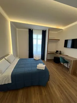 a bedroom with a bed and a desk and a television at Maison Butera in Palermo