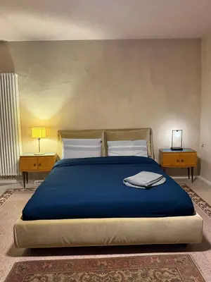 a bedroom with a large blue bed with two tables at Xenia Signature Guest House in Palermo