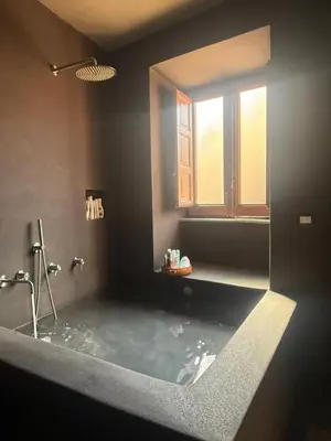 a bathroom with a tub with a toilet and a sink at Xenia Signature Guest House in Palermo