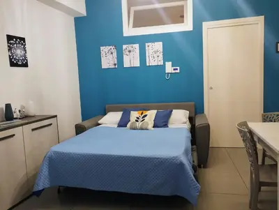 a bed with a blue blanket on top of it at Aria di Paese in Altavilla Milicia