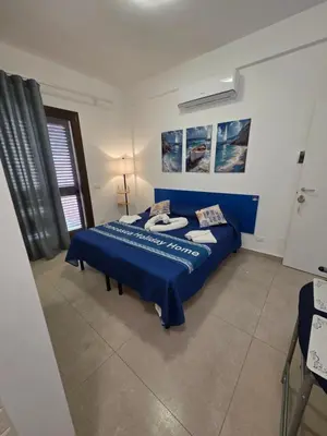 a bedroom with a blue bed in a room at Francesca Holiday Home in Castellammare del Golfo