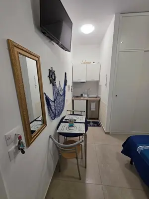 a room with a table and a mirror on a wall at Francesca Holiday Home in Castellammare del Golfo
