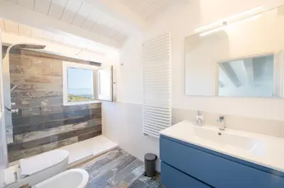 a bathroom with a sink and a toilet at Villa Baja Scopello in Balata di Baida