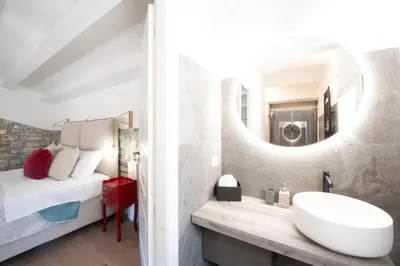 a bathroom with a sink and a bed and a mirror at Villa Baja Scopello in Balata di Baida