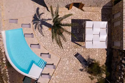 an overhead view of a swimming pool and a palm tree at Villa Baja Scopello in Balata di Baida