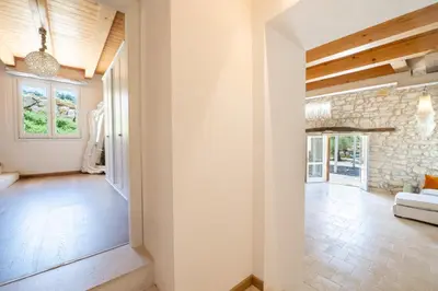 a living room with a stone wall and a fireplace at Villa Baja Scopello in Balata di Baida