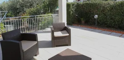two wicker chairs sitting on a patio at Casa Verdemare in Cefalù