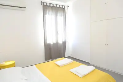 a room with two beds and a yellow blanket at Casa Verdemare in Cefalù